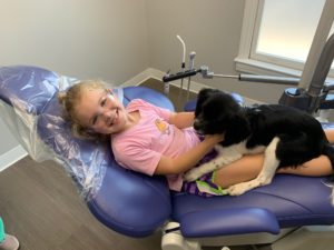 young child at the dentist with a therapy dog