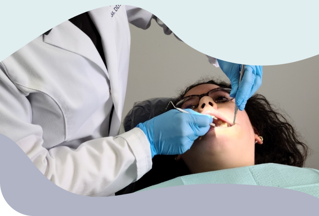 A dentist performs a gentle dental exam on a patient reclined in the chair, showcasing compassionate care tailored by a special needs dentist.