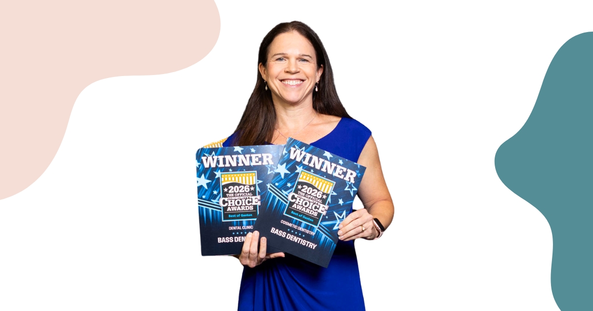 Dr. Diana Bass smiling while holding two 2026 Best of Gaston awards for Dental Clinic and Cosmetic Dentistry.